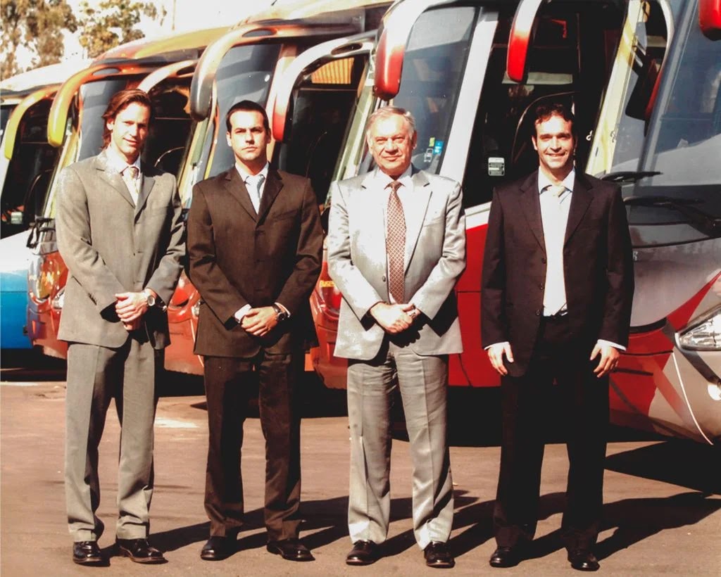 Equipo directivo de Grupo Cabal frente a su flota de buses